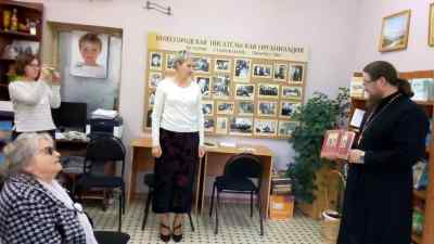 Отец Дионисий передает книги в дар Центру писателей.